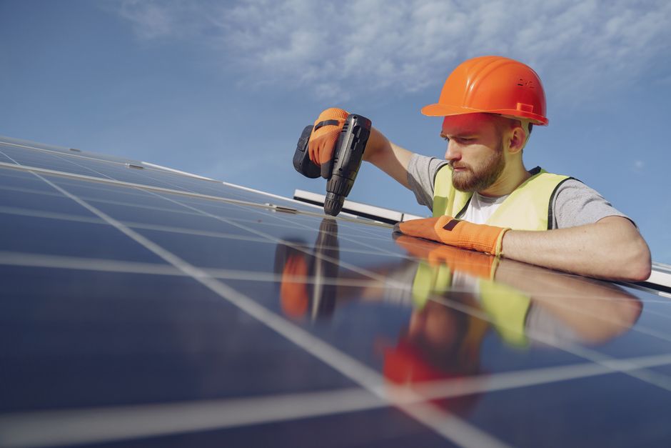 Professional worker completing a solar installation on a roof